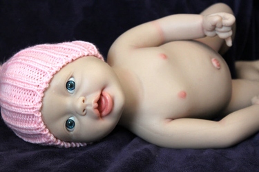 full platinum silicone doll with a pink hat